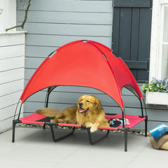 Dog relaxing on a red dog cot cooling pet bed with shelter on a patio.